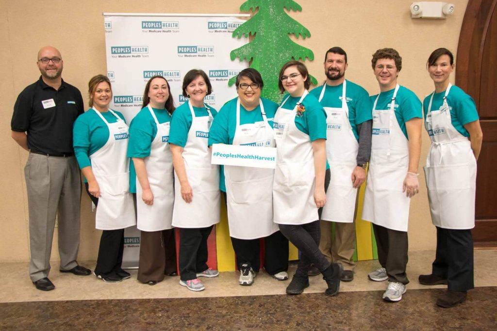 Image of Peoples Health employees holding a sign that says #peopleshealthharvest
