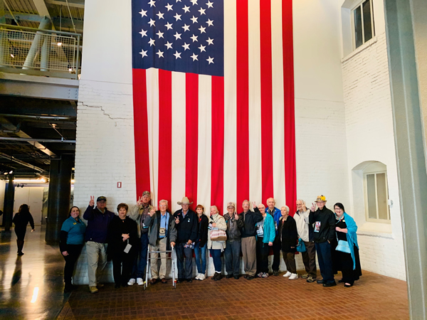 Seniors standing in front of flag