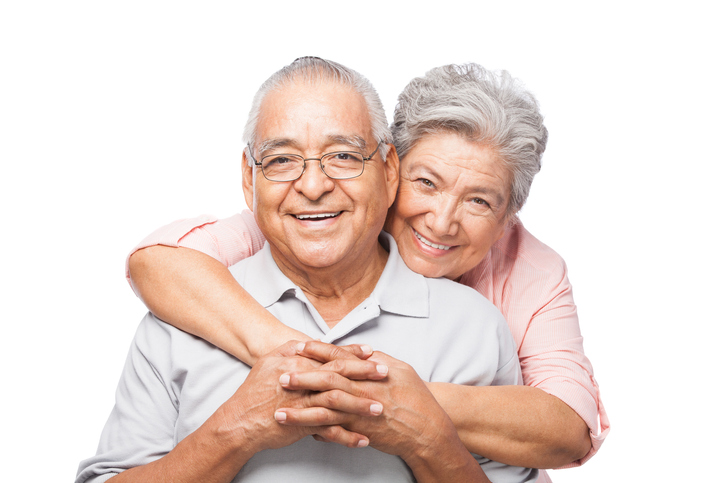 Senior male and female embracing and smiling.